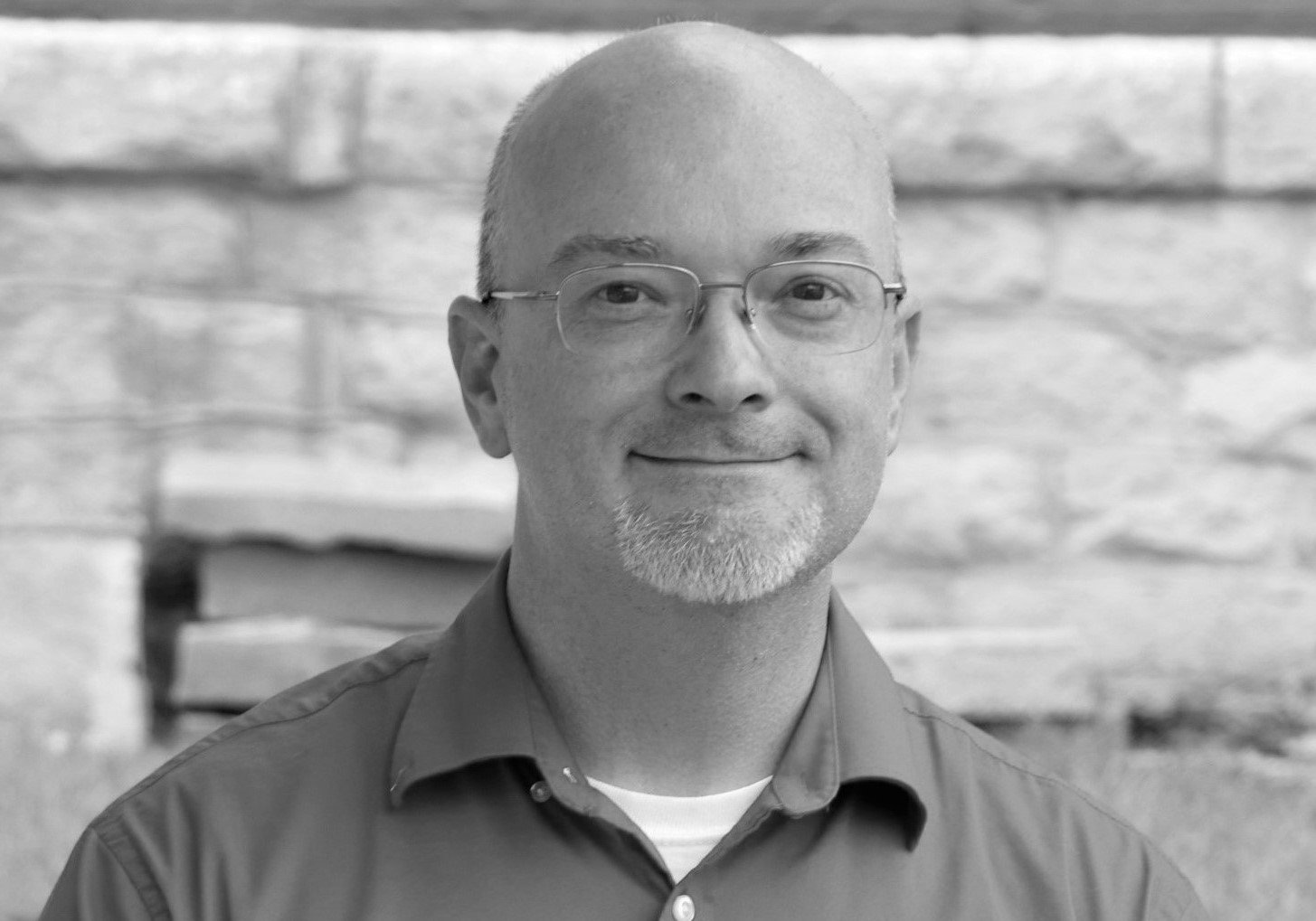 A middle-aged man with a goatee and glasses, associated with the Elbert Theatre Foundation, smiles at the camera in this black-and-white portrait.